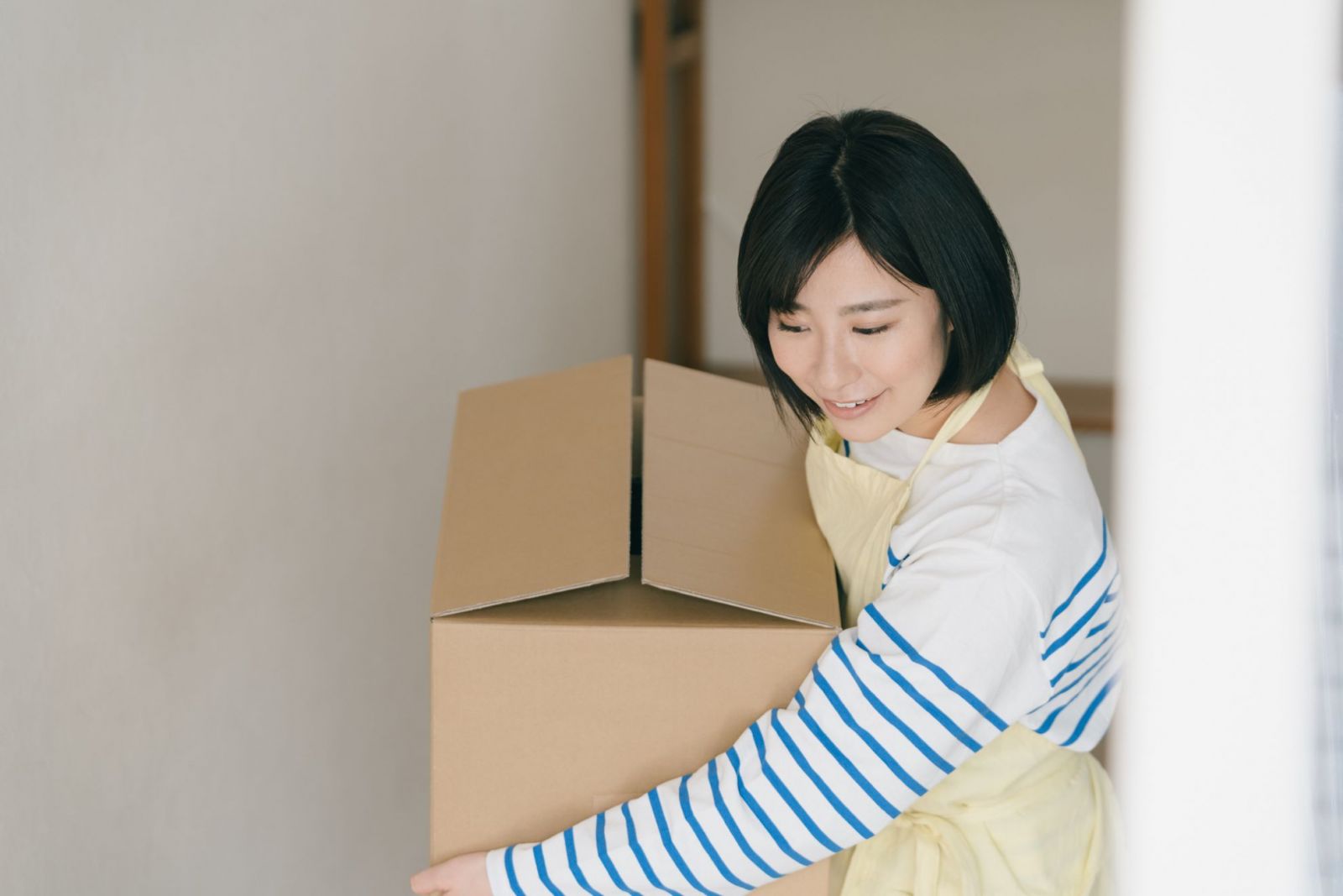 段ボールを運んでいる女性